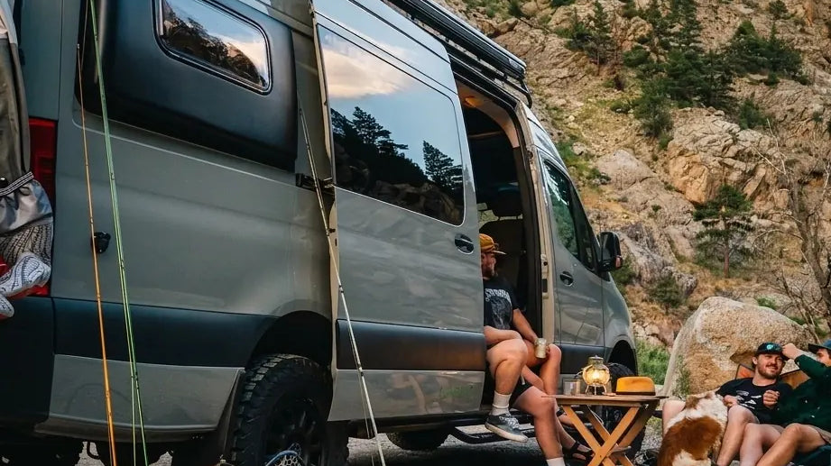 boondocking - Friends camping by van with fishing gear and dog