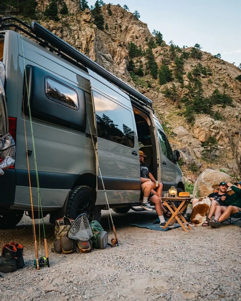 boondocking - Friends camping by van with fishing gear and dog