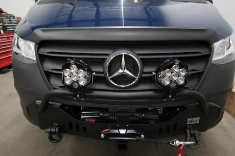 build mercedes - This image shows the front exterior of a Mercedes-Benz Sprinter van inside a gar