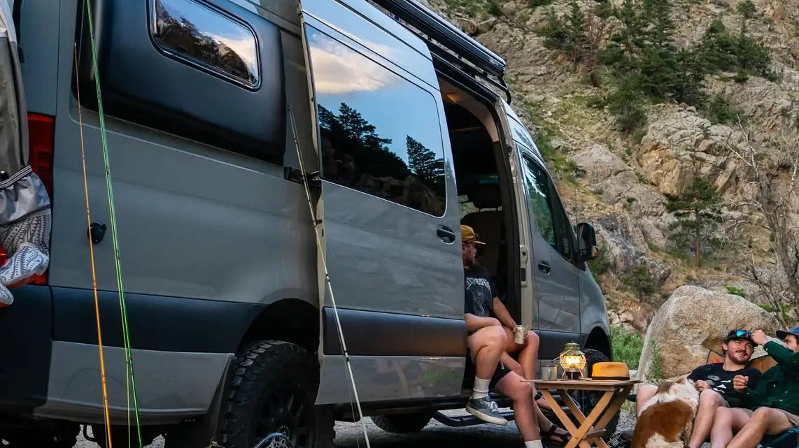 camp conversion - Friends camping by van with fishing gear and dog