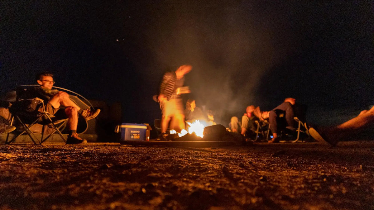 campfire games - The prominent feature in this image is the warm glow of the campfire at the cent