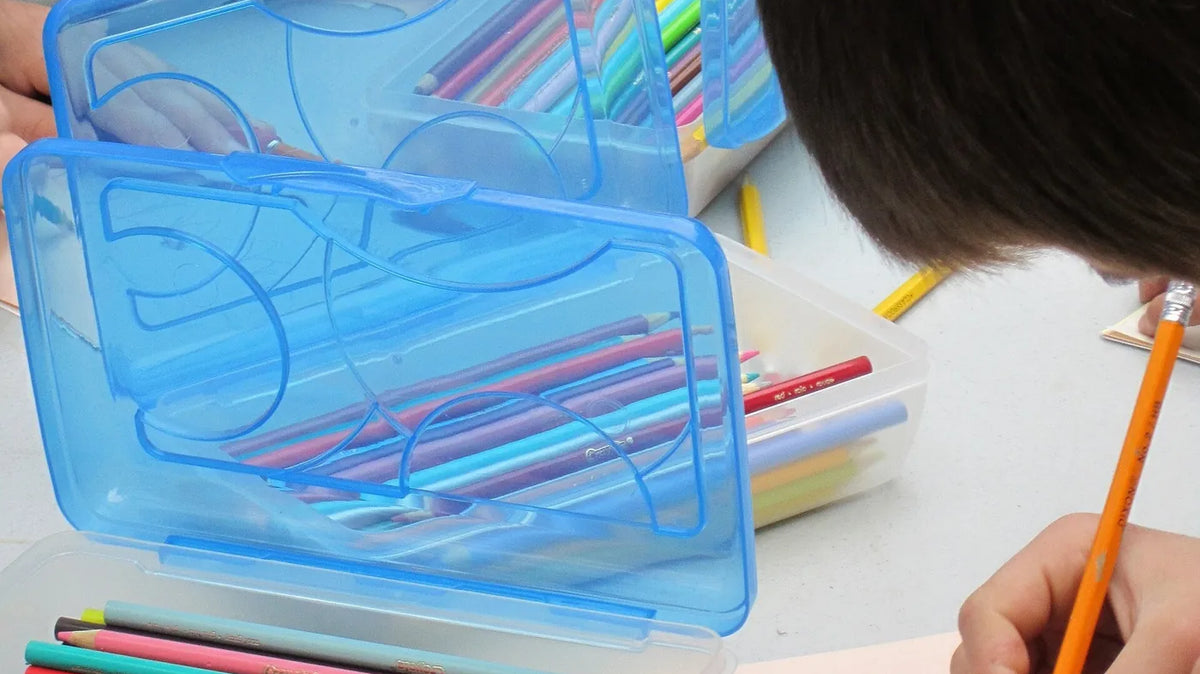 Camping Craft Ideas - Colored pencils in a clip-shut plastic case on an outdoor table