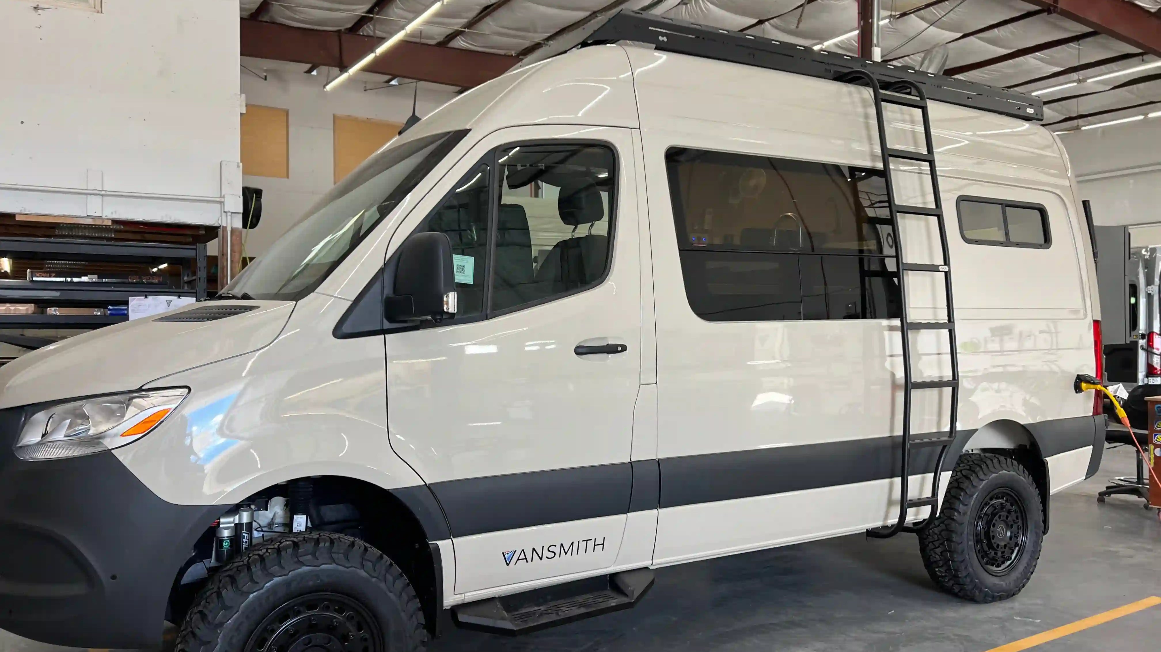 Vansmith-built Class B camper van: Sprinter 4x4 high roof with roof rack, ladder, and off-road tires