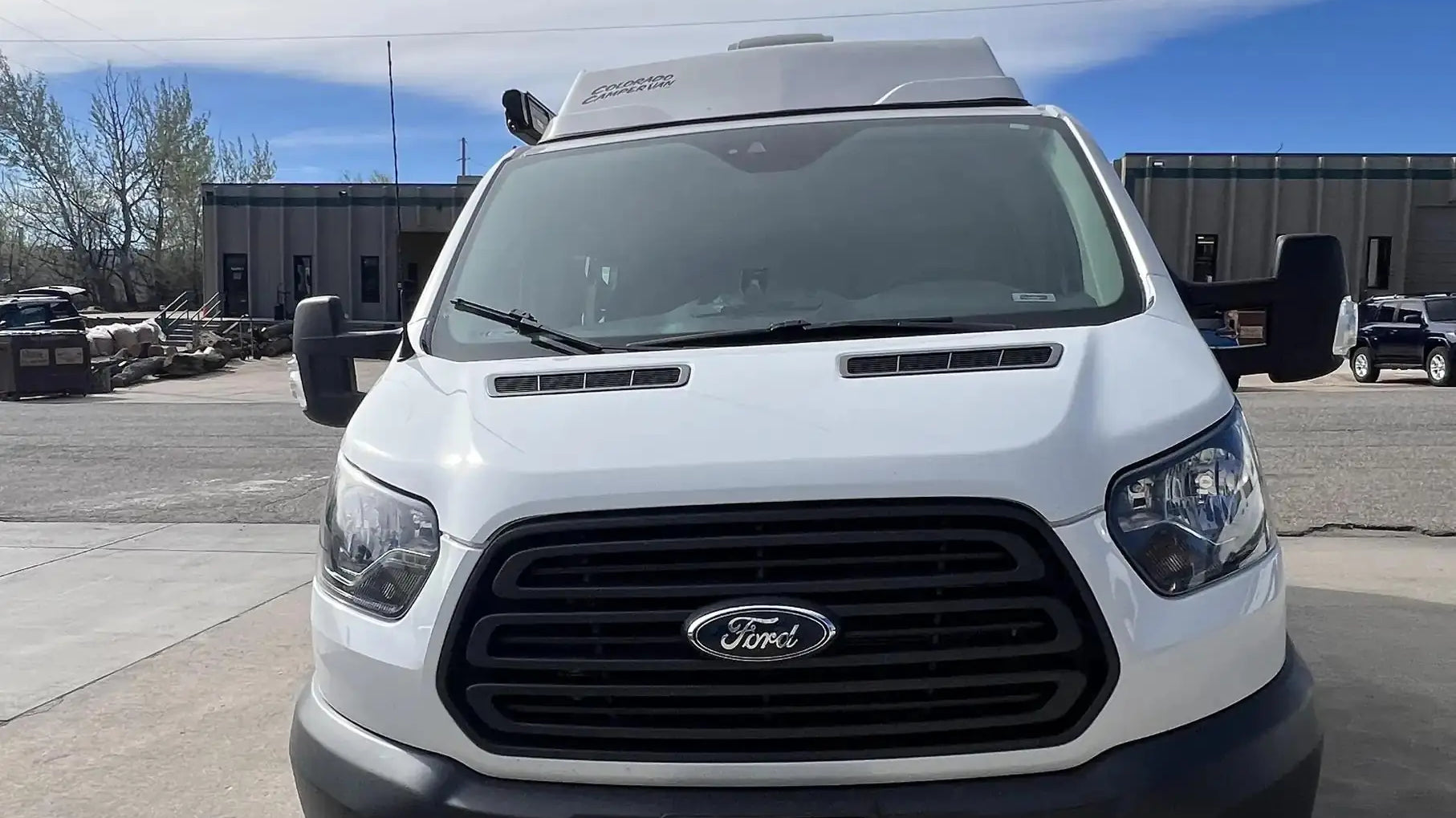 colorado camper van - The image shows the front exterior of a white Ford camper van with a high roof e