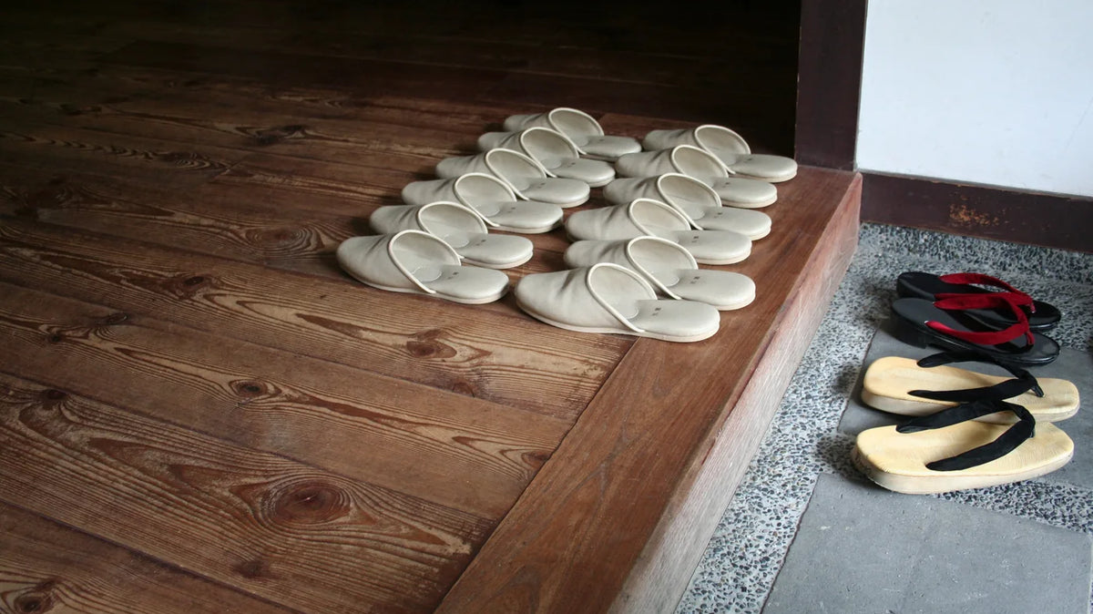 Haflinger clogs - A row of house slippers lined up on a wooden step inside a doorway