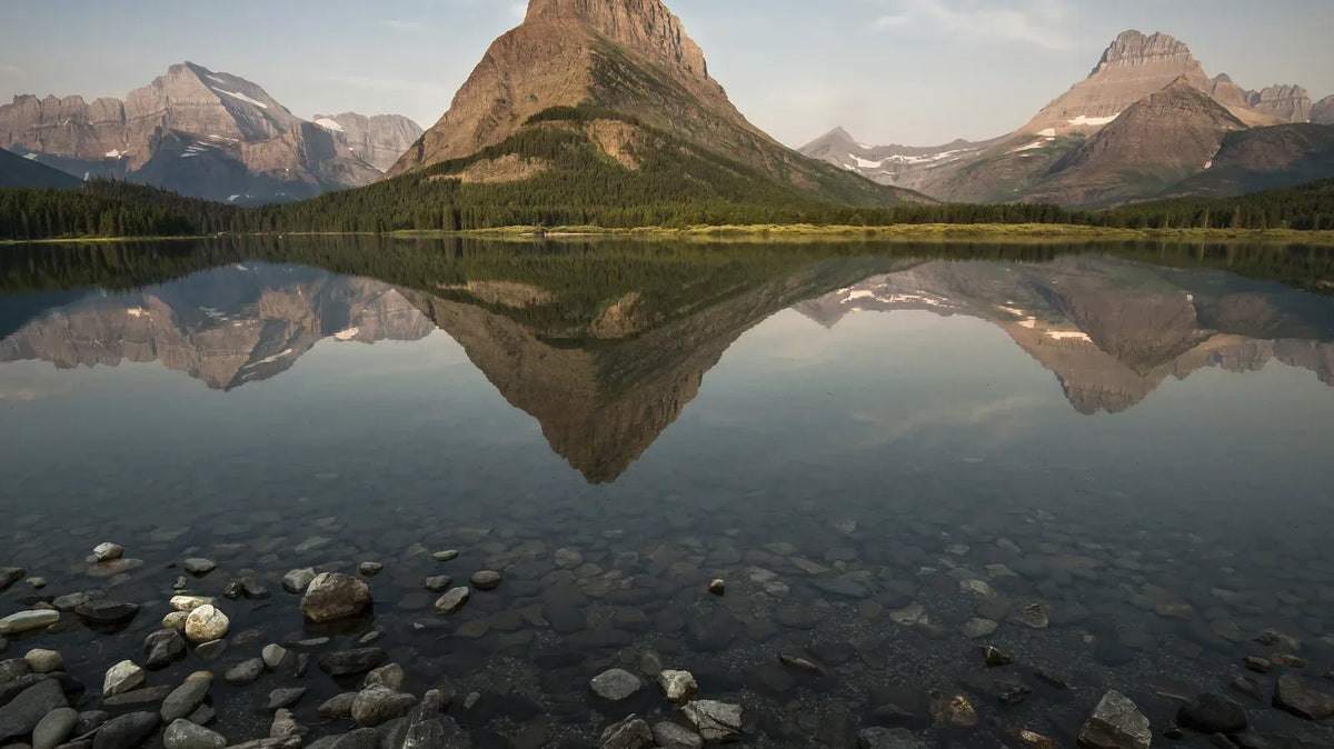 Montana Camping - Grinnell Point reflected in Swiftcurrent Lake at sunrise near Many Glacier, Glacier National Park