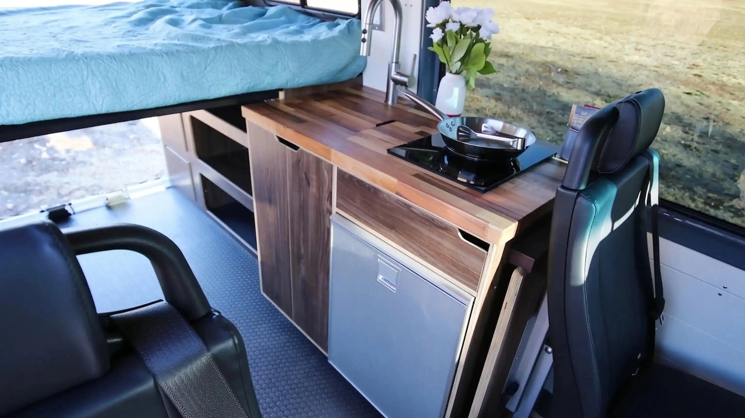 small camper sleeps 4 - Compact camper van interior with bed, kitchen, and seating