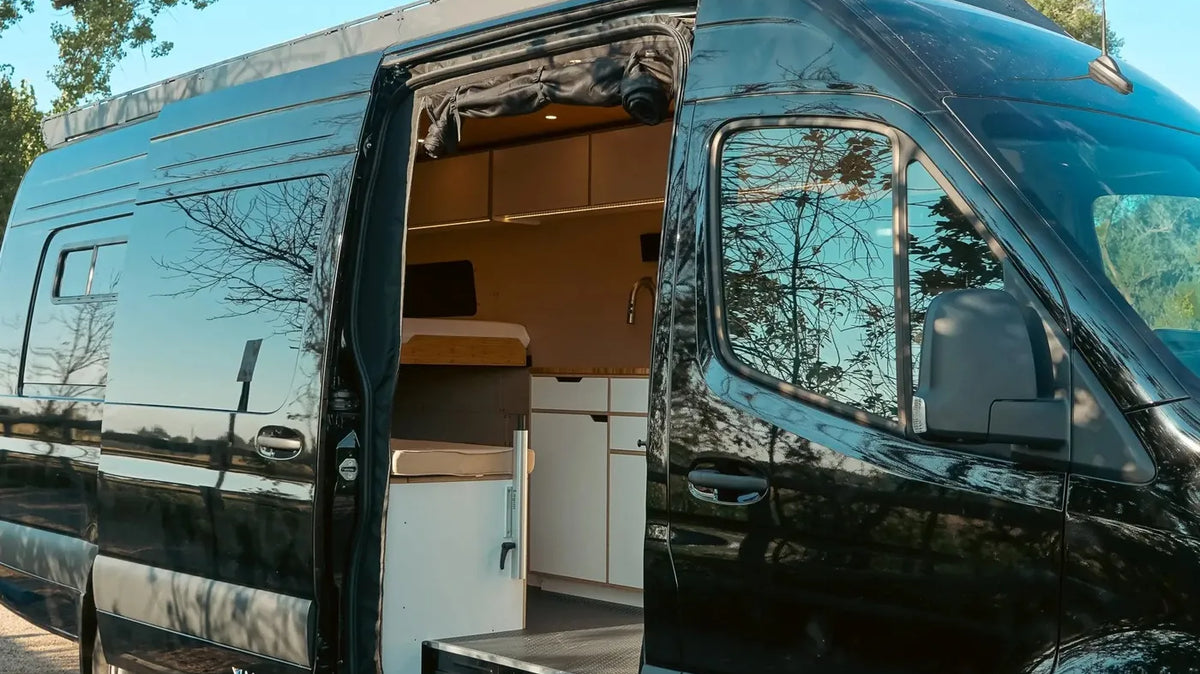 Small RVs vs Camper Vans - A black Vansmith Sprinter camper van with its sliding door open