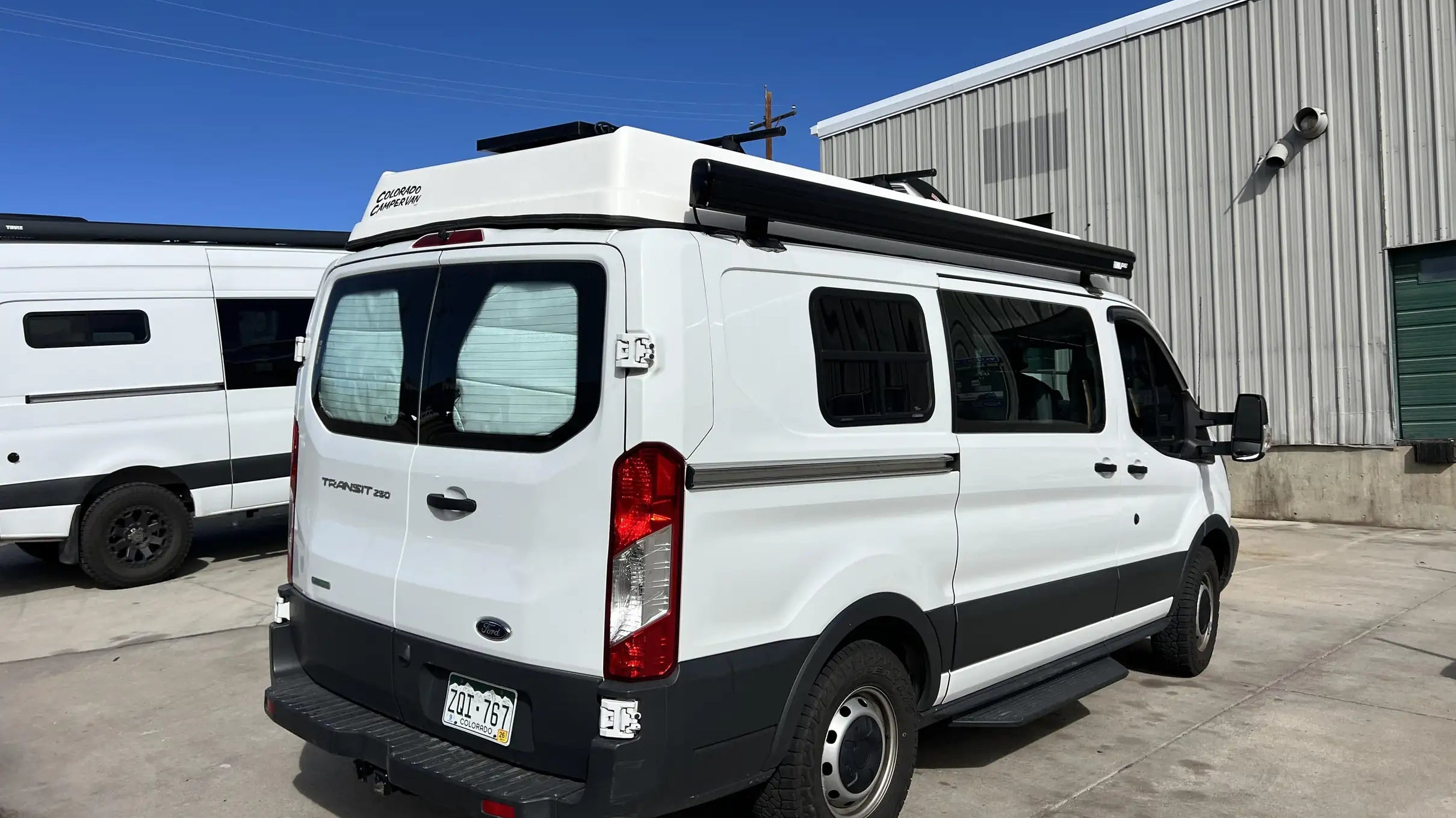 van conversion companies colorado - This image shows a white Ford Transit 250 camper van conversion named "Colorado