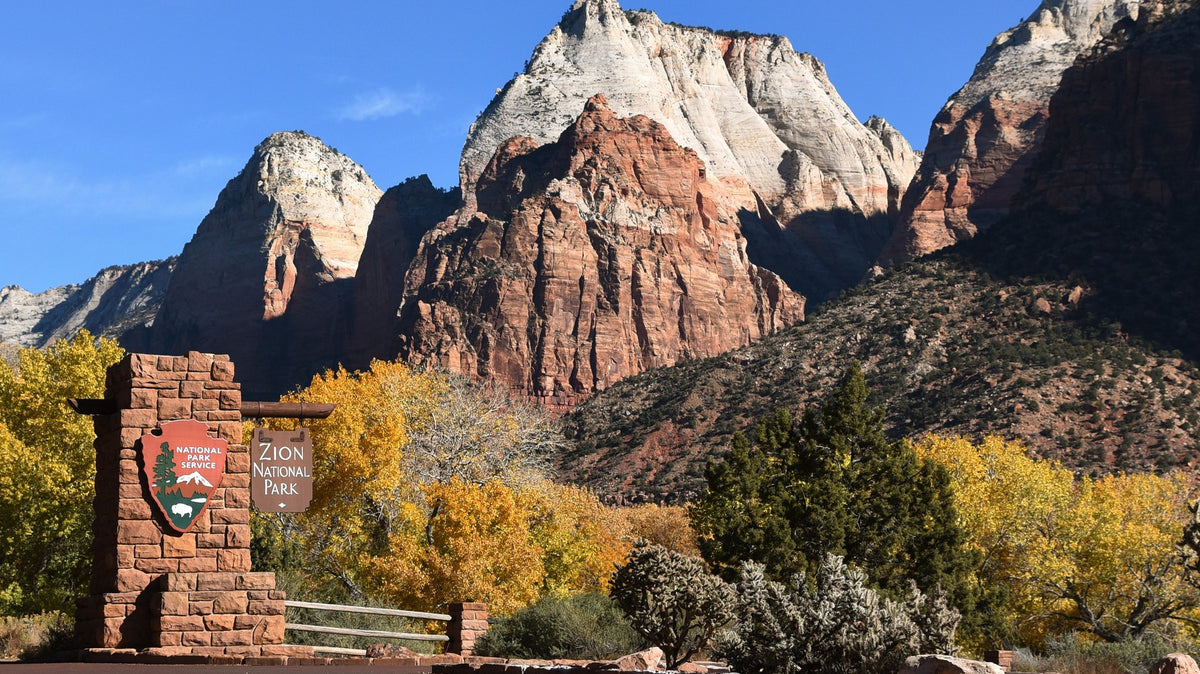 Las Vegas to Zion National Park - Zion National Park entrance sign with the Twin Brothers peaks rising behind it