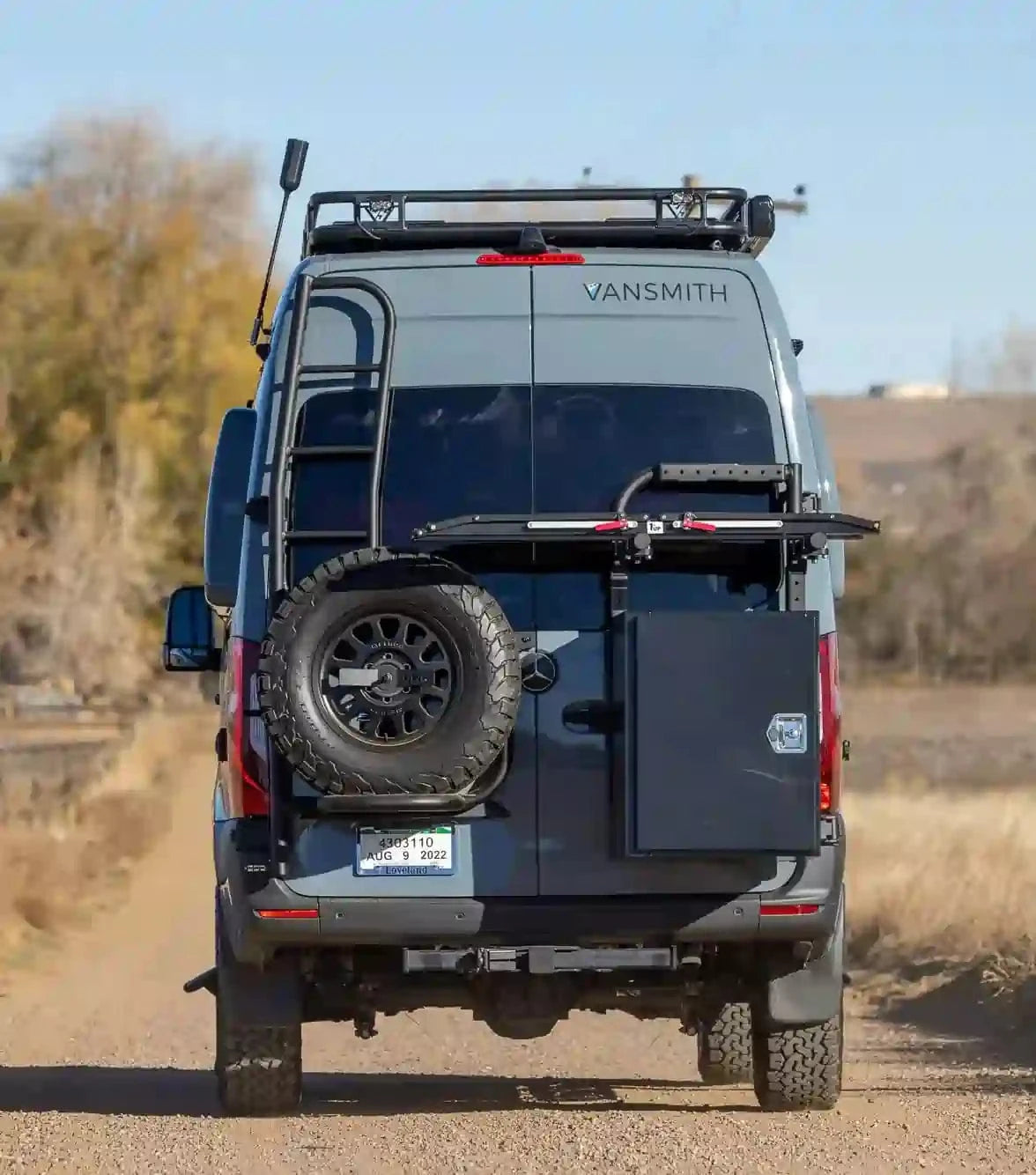 Back of Custom Sprinter Adventure Van with Racks, Ladder, Spare Wheel and The Vansmith Logo