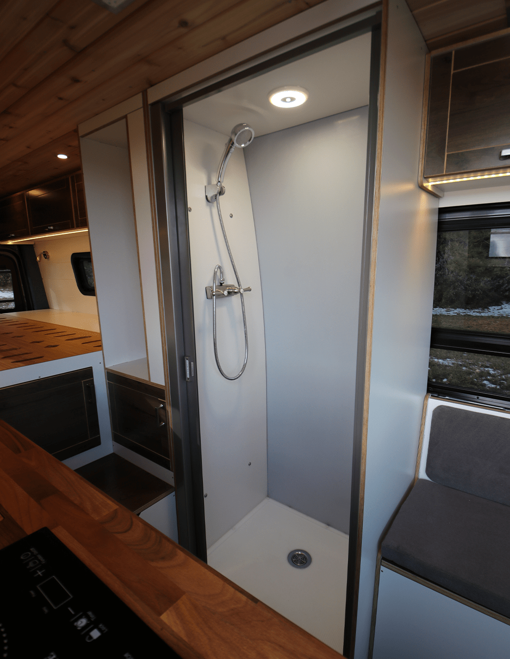 Modern Stand-Up Shower with Light in Custom Camper Van Conversion by The Vansmith