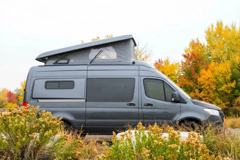 best camper van for tall people - Gray camper van parked with elevated roof for camping