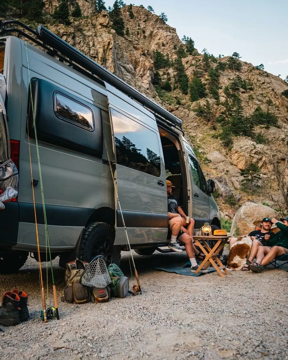 boondocking - Friends camping by van with fishing gear and dog