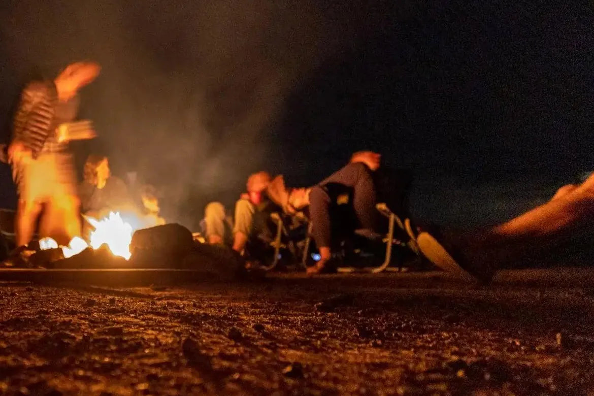 Campfire Games - Campers relaxing around a campfire at night