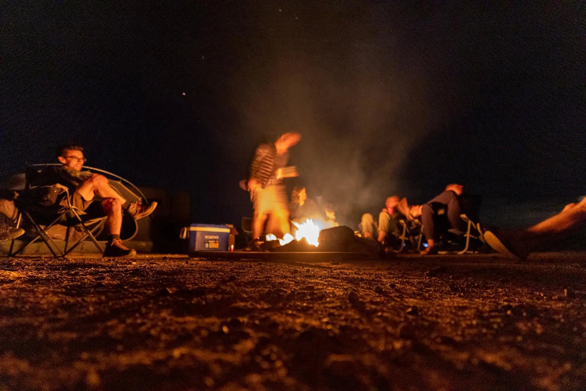 campfire games - The prominent feature in this image is the warm glow of the campfire at the cent