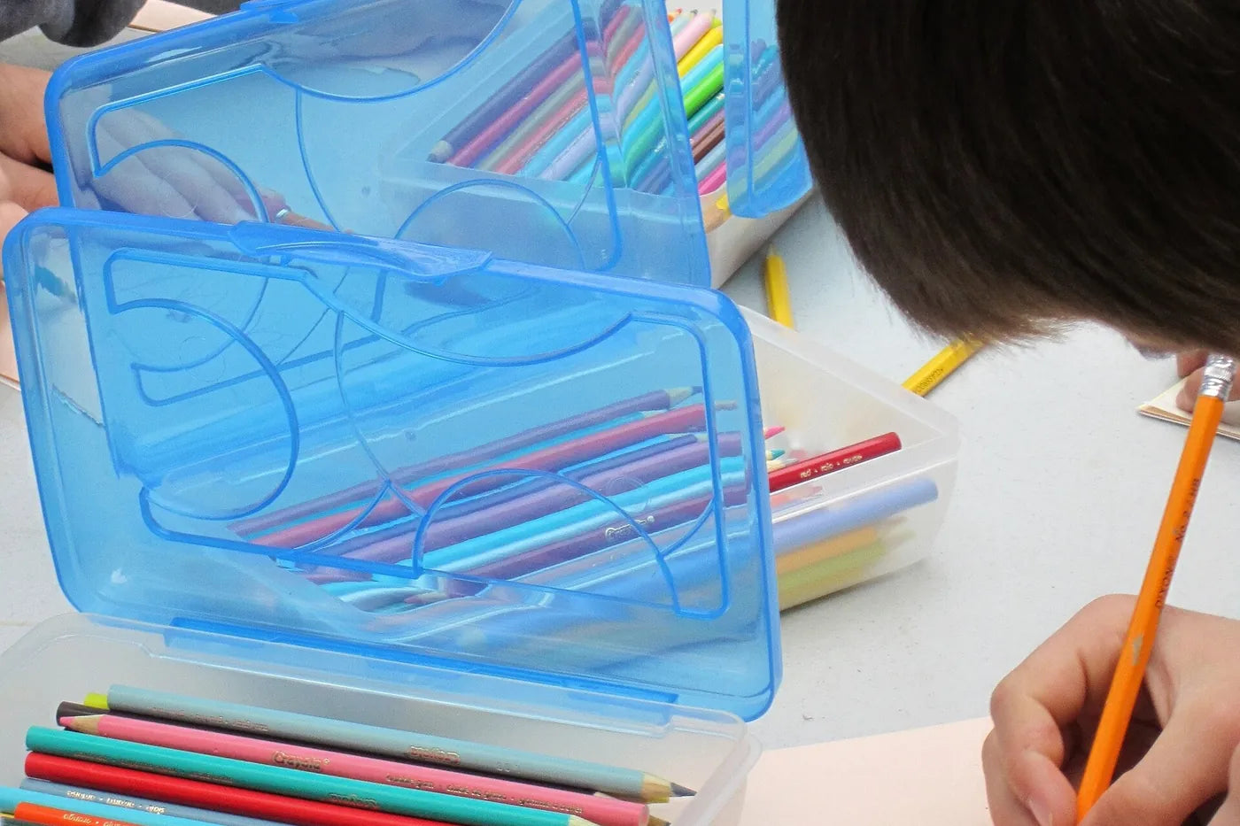 Camping Craft Ideas - Colored pencils in a clip-shut plastic case on an outdoor table