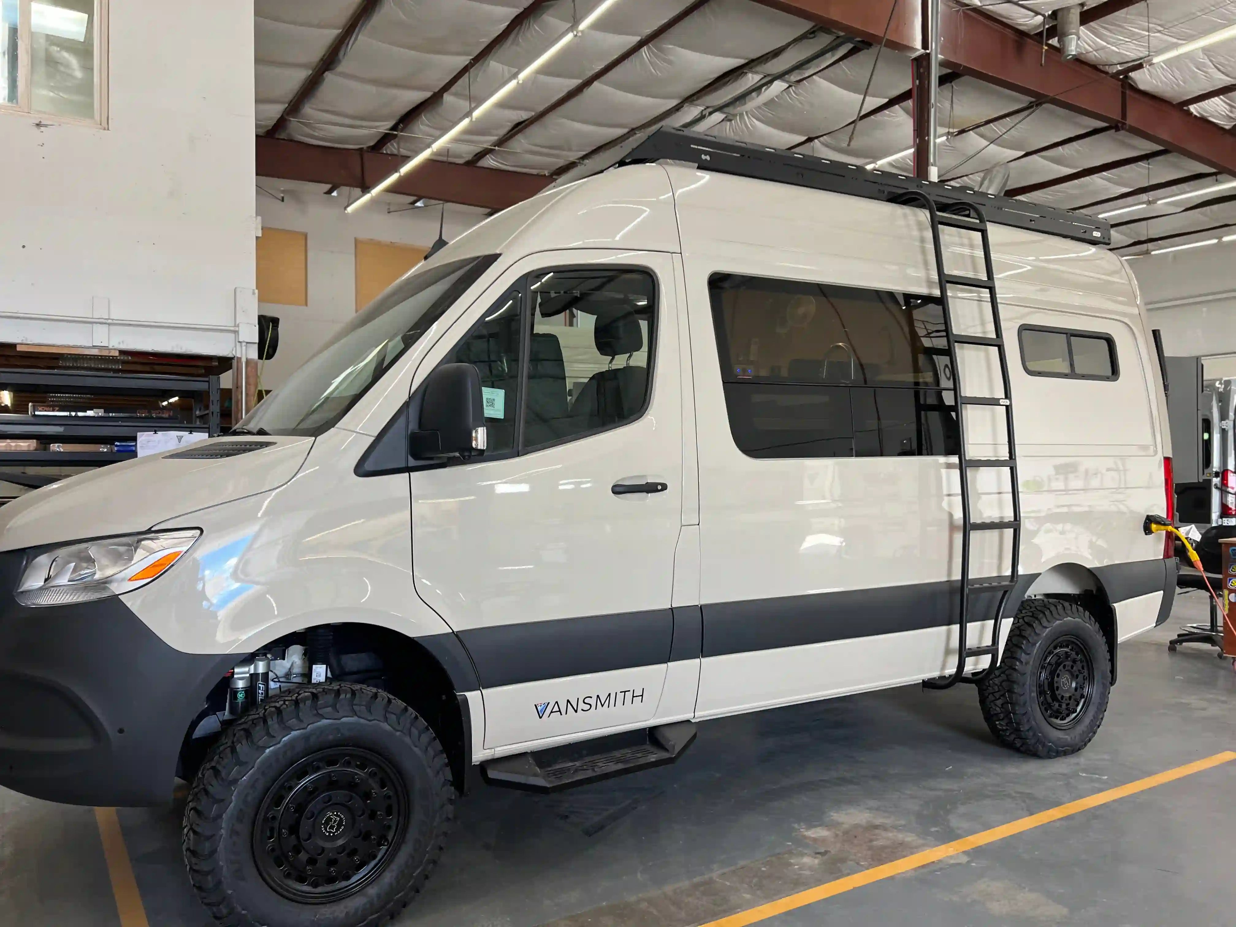 Vansmith-built Class B camper van: Sprinter 4x4 high roof with roof rack, ladder, and off-road tires