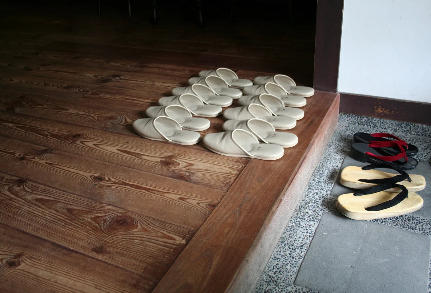 Haflinger clogs - A row of house slippers lined up on a wooden step inside a doorway
