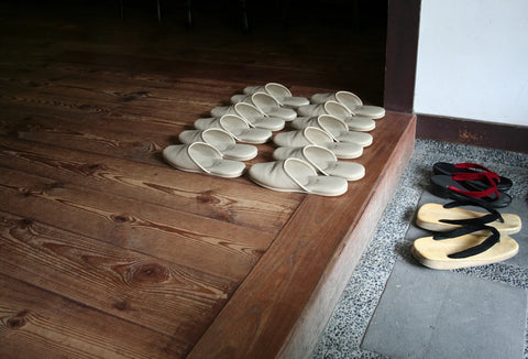 Haflinger clogs - A row of house slippers lined up on a wooden step inside a doorway