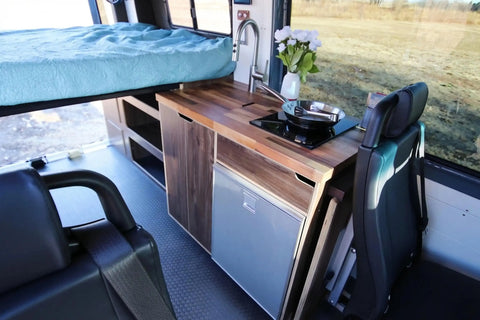 small camper sleeps 4 - Compact camper van interior with bed, kitchen, and seating