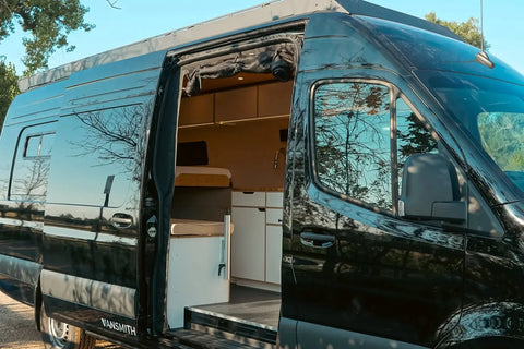 Small RVs vs Camper Vans - A black Vansmith Sprinter camper van with its sliding door open