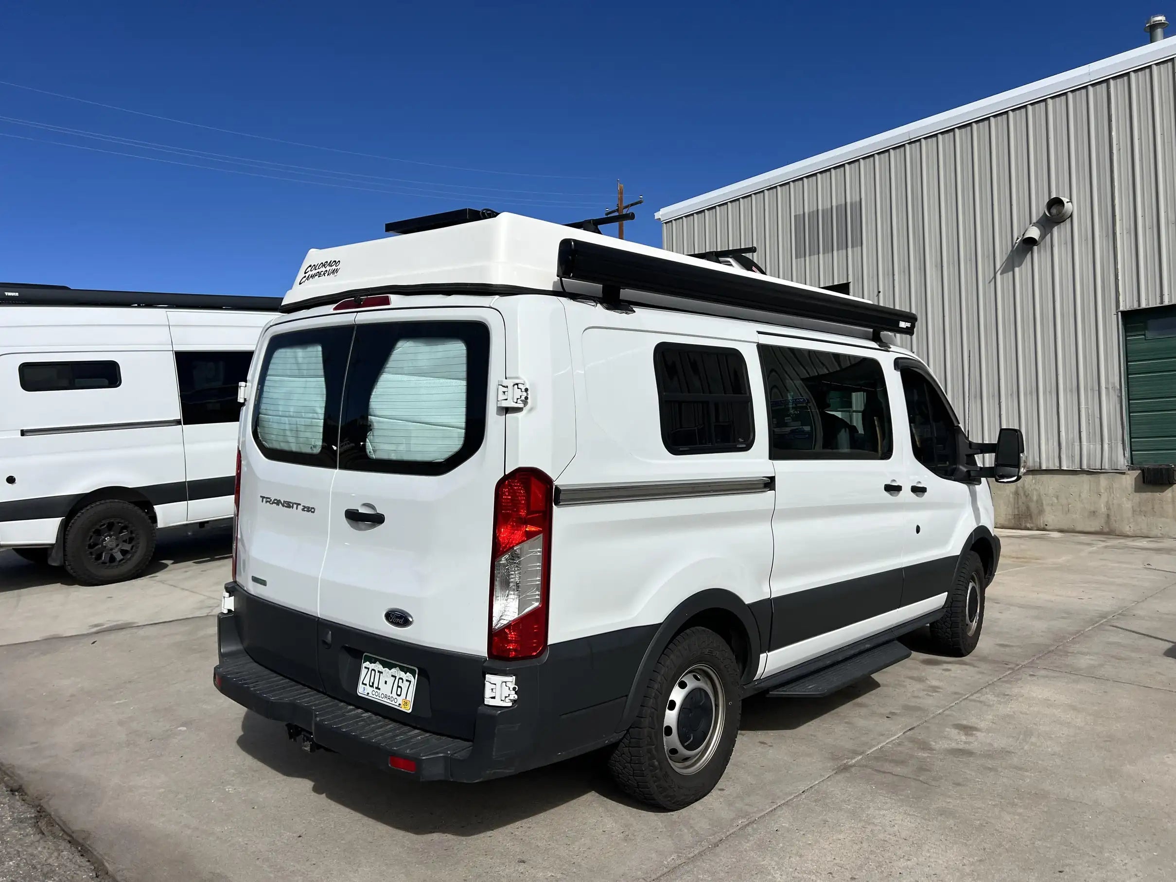van conversion companies colorado - This image shows a white Ford Transit 250 camper van conversion named "Colorado 