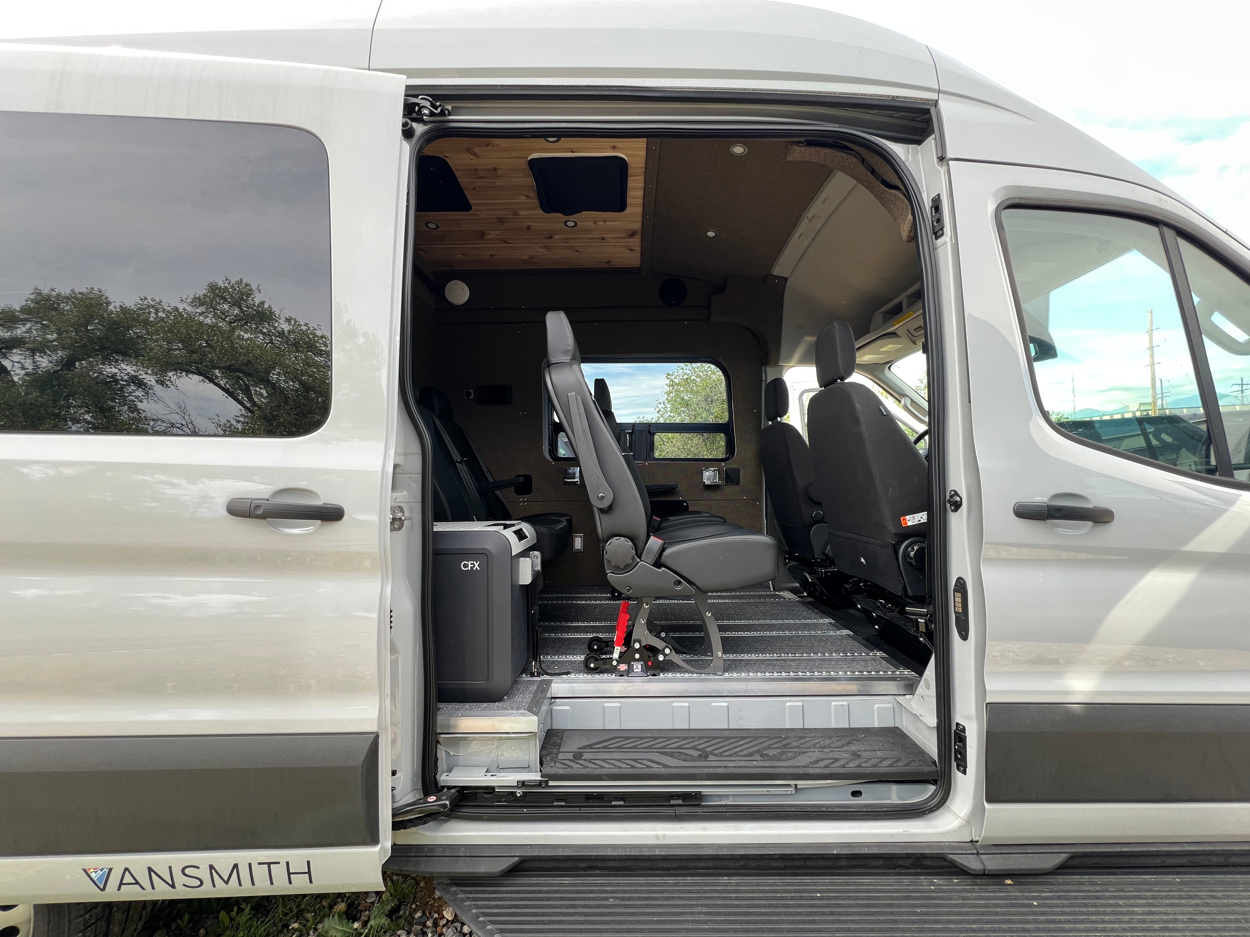 Interior view through sliding door — seats and Dometic fridge