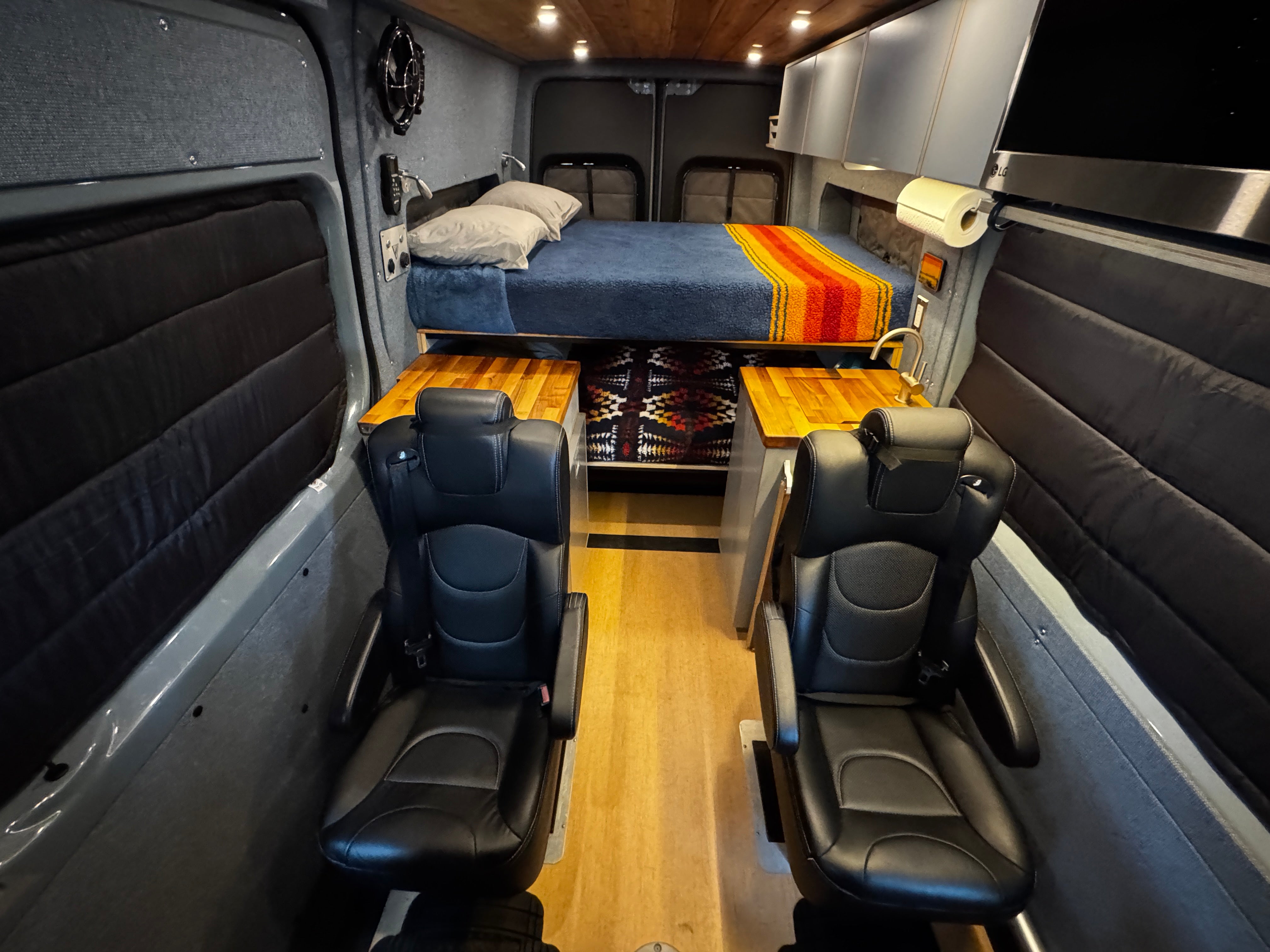 Interior toward rear, daytime, bed and dinette