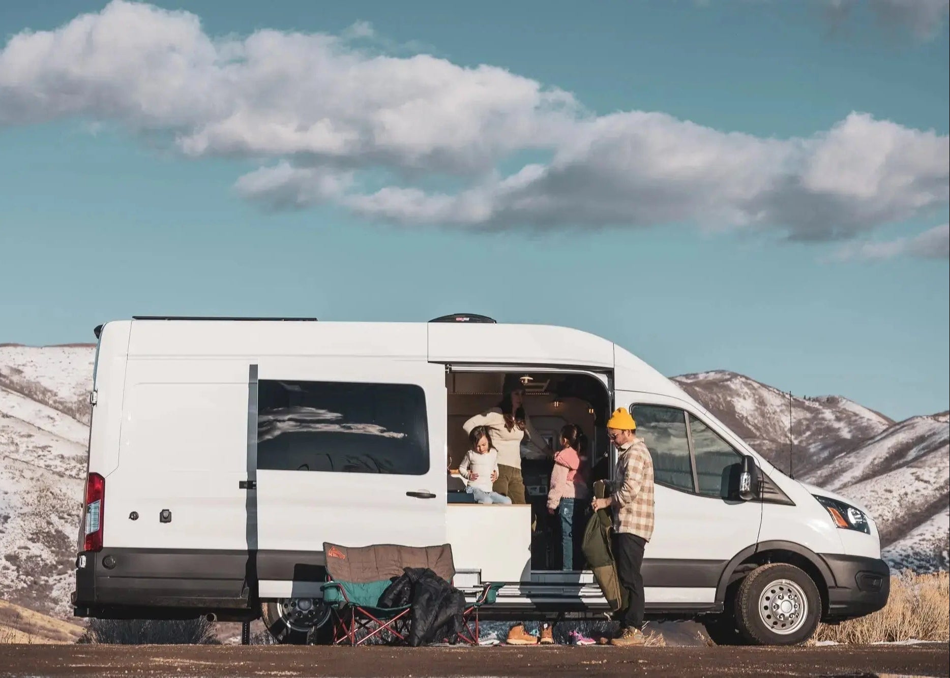 Family at Side Door of FAMILY XL PLUS Ford Transit AWD Camper Van for Sale in Front of Colorado Mountains – The Vansmith