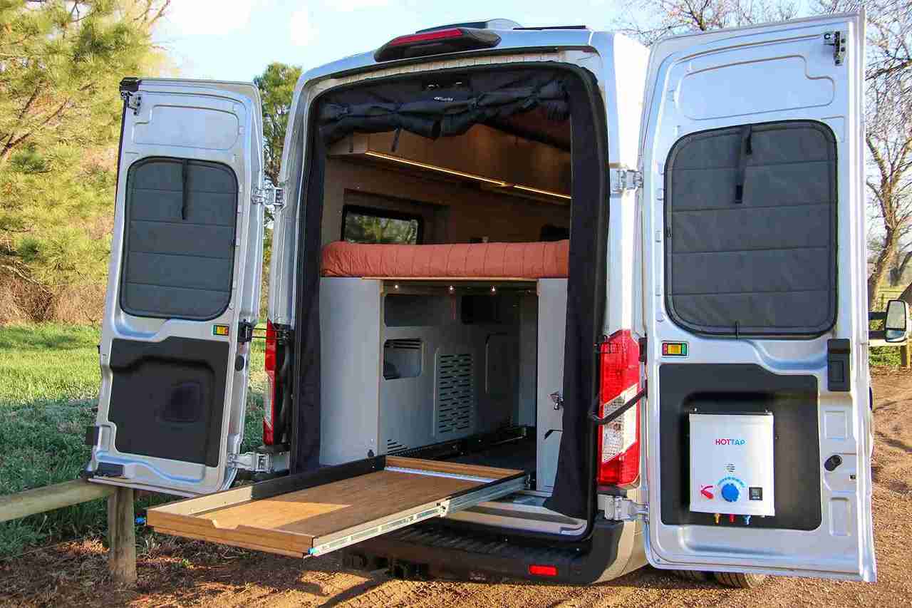 Rear View of Ford Transit Van Conversion by The Vansmith with Raised Bunk Bed and Slide-Out Cargo Tray from Storage Garage