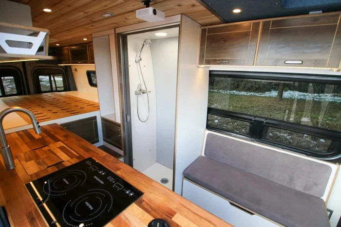 Enclosed Shower and Finished Kitchen Countertop with Stove in Sprinter Family Van Conversion by The Vansmith