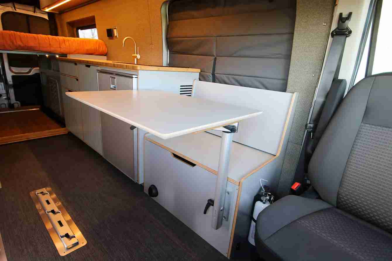 Storage Bench Seat with Retractable Kitchen Table in Ford Transit Camper Van Conversion by The Vansmith