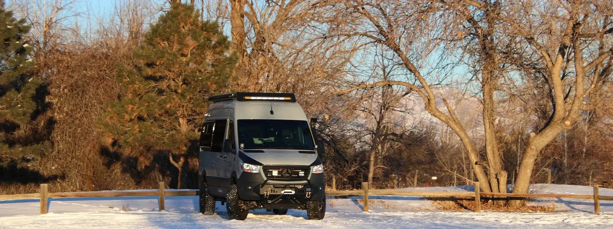 High-End Wood-Finish Kitchen Galley with Stove, Fridge and Sink in Family Van Conversion by The Vansmith