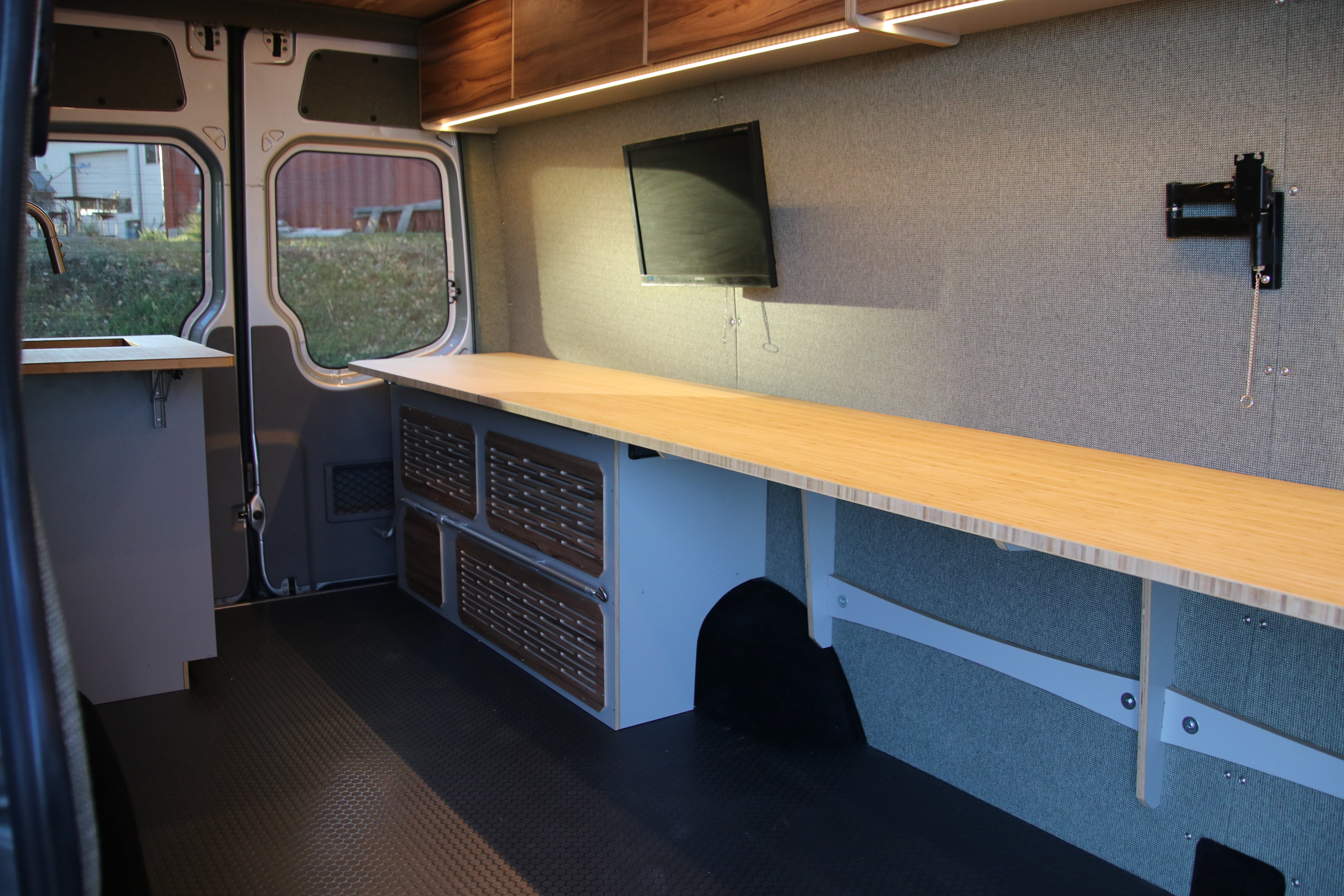 Sprinter van interior with ergonomic office desk, swivel chair, and power outlets