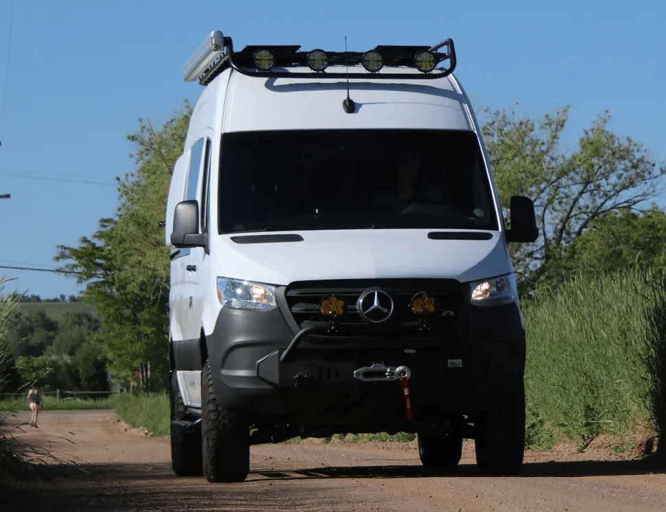 Front Exterior of White Sprinter Van Conversion by The Vansmith with Roof Cargo Rack and Lights