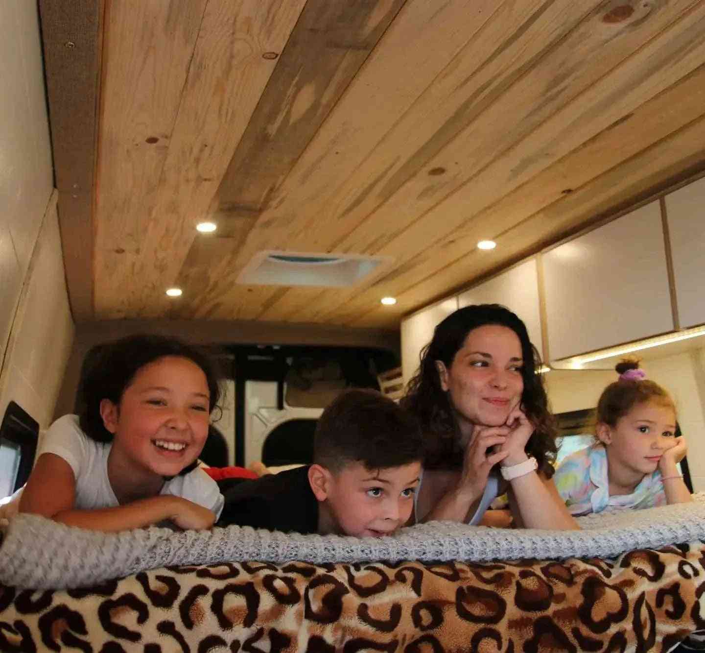 Mother and Three Kids on Bed in Van Conversion for Families by The Vansmith