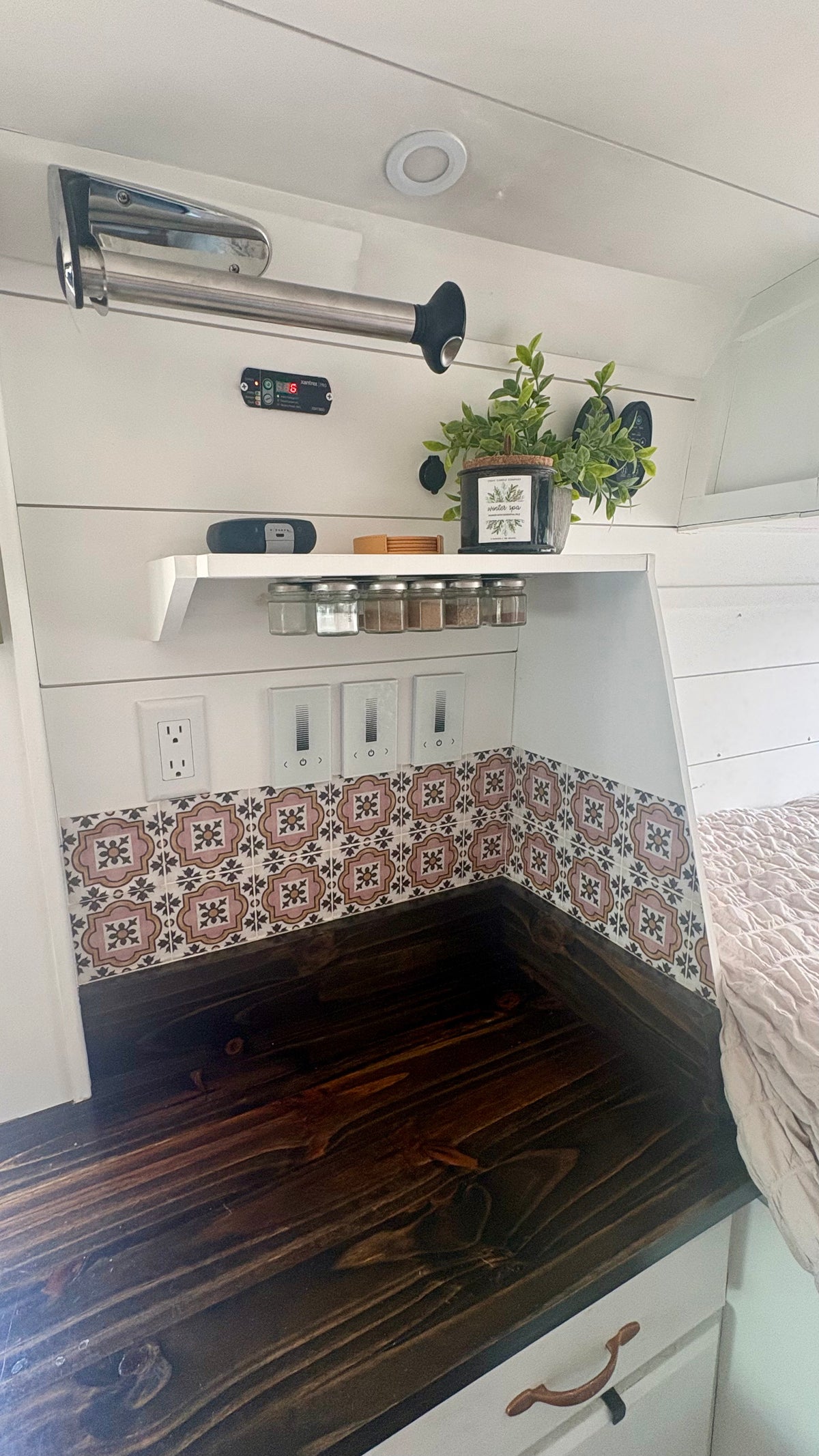 Galley detail with tile backsplash, butcher block counter and spice shelf