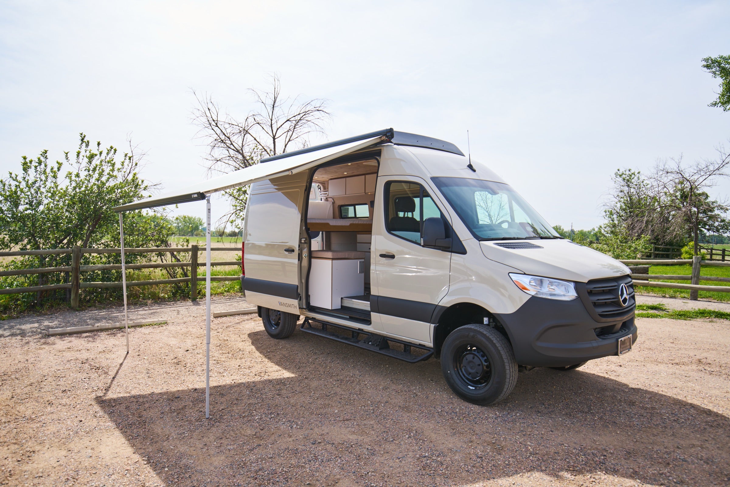 Side view of Sprinter Bivy Classic camper van with awning extended at campsite - The Vansmith