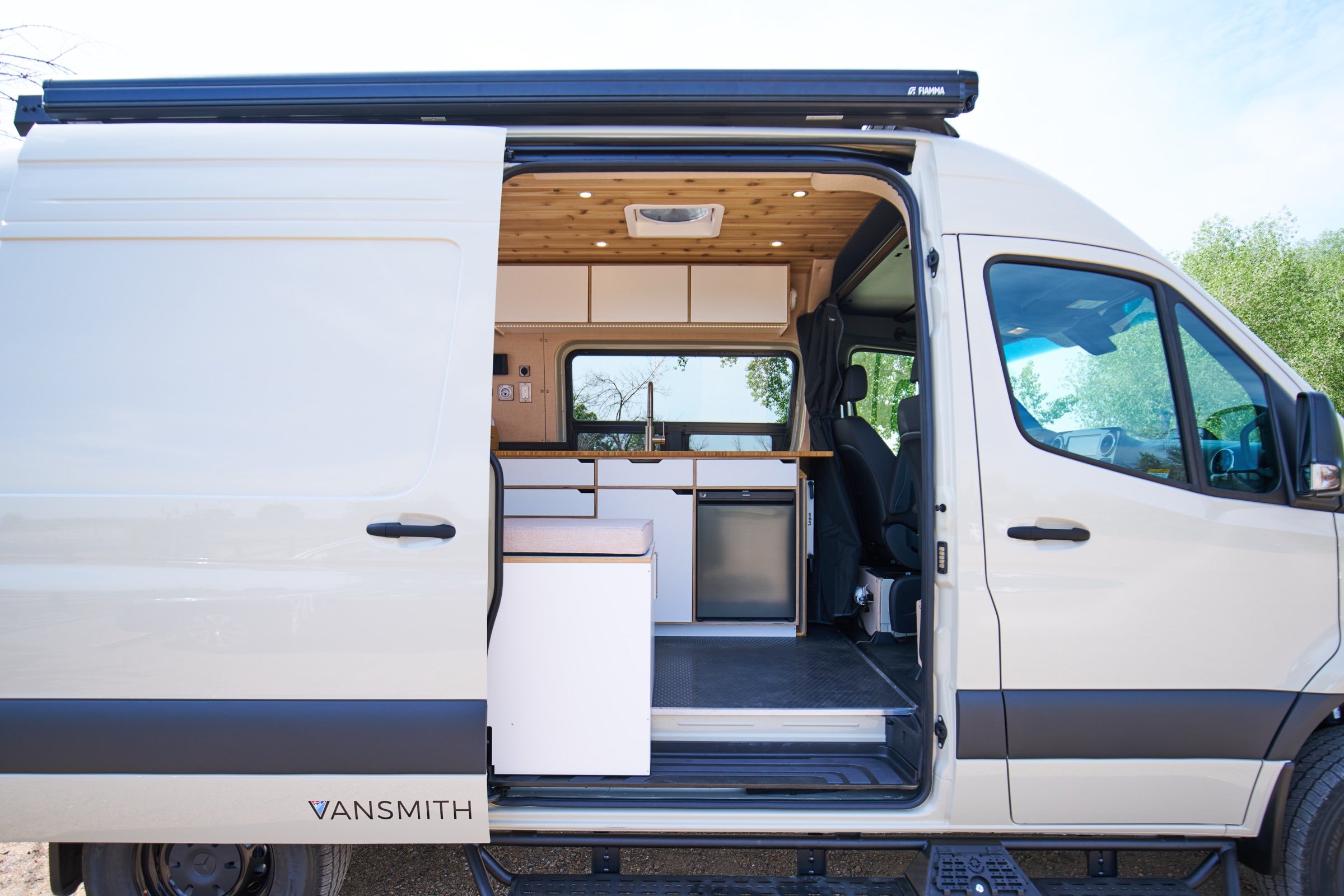 Side view of Sprinter Bivy Classic camper van with sliding door open and awning extended - The Vansmith