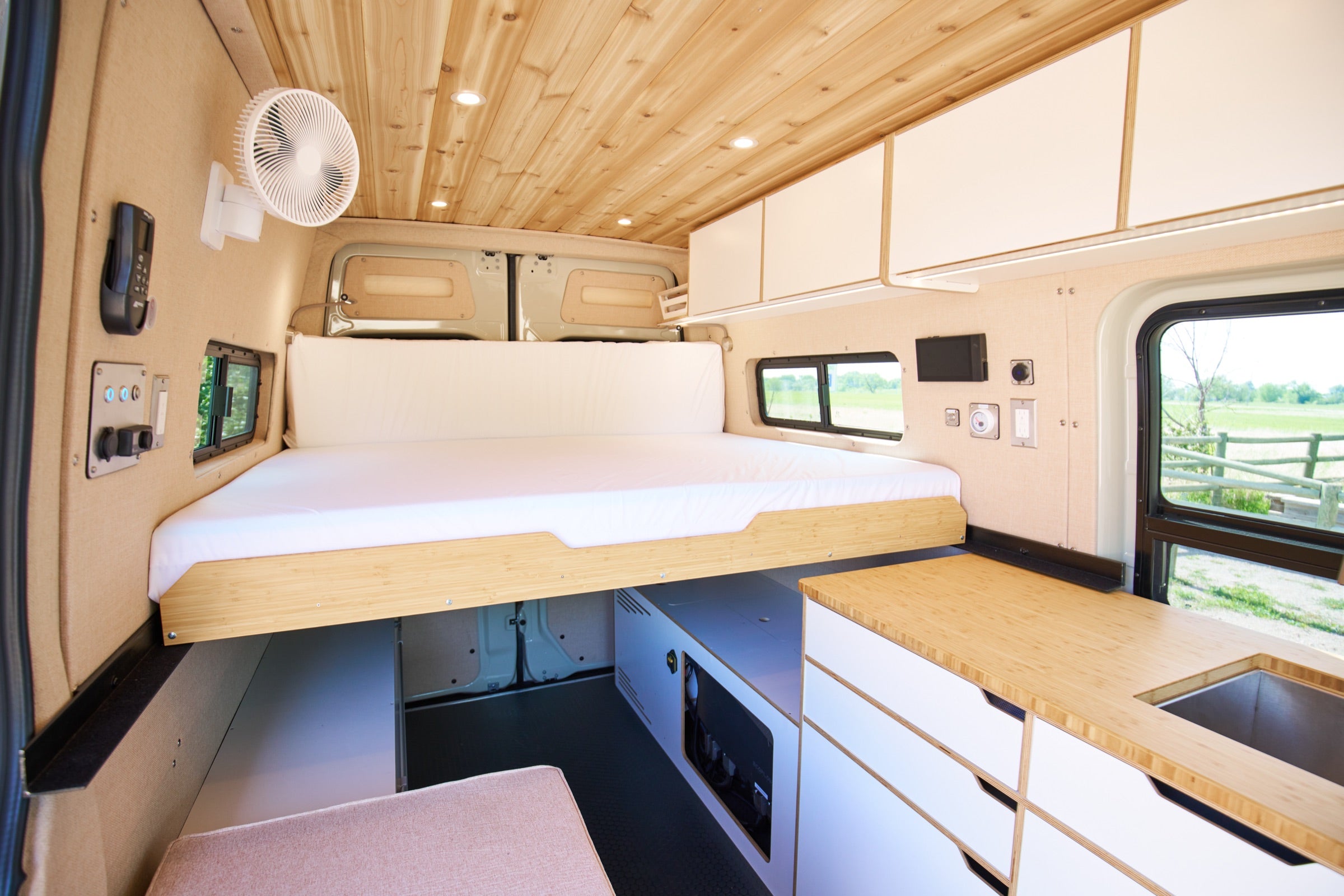 Interior of Sprinter Bivy Classic camper van showing bed, kitchen galley and cedar ceiling - The Vansmith