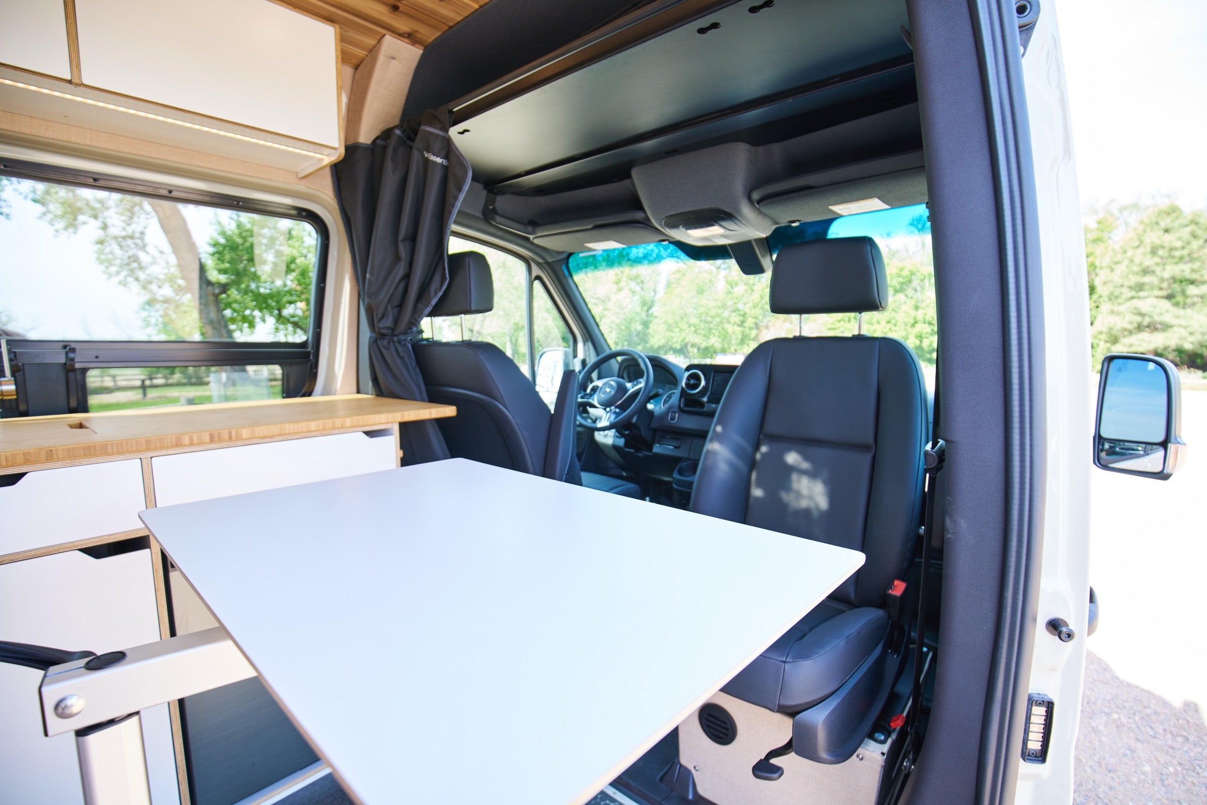 Cab area and dinette table inside Sprinter Bivy Classic camper van - The Vansmith