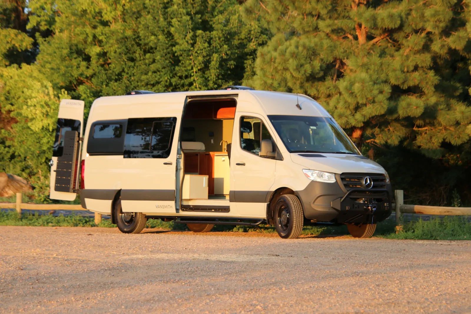 White Mercedes Sprinter 170 AL van conversion parked with sliding door open showing interior
