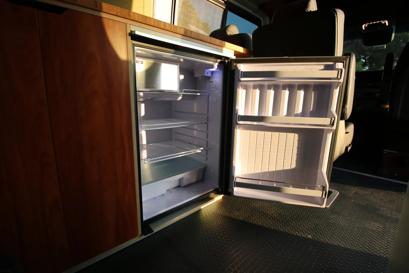Built-in refrigerator with interior lighting inside AL Sprinter van conversion by The Vansmith