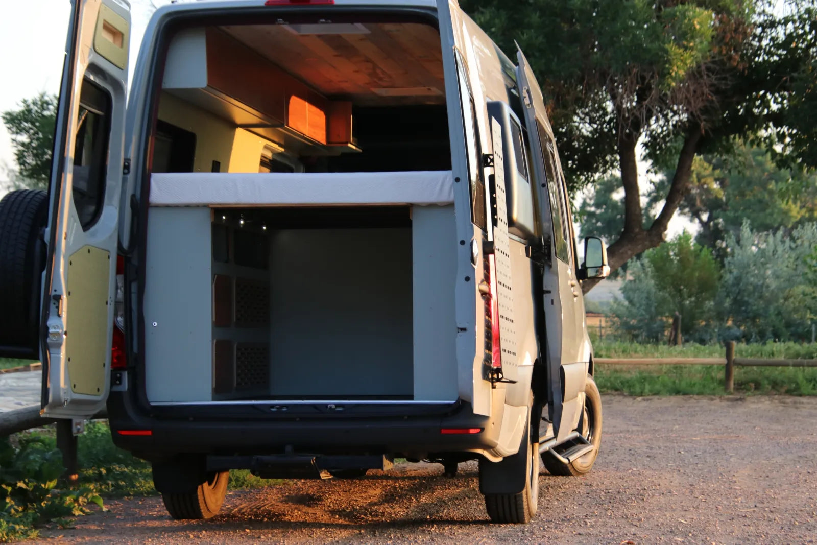 AL Sprinter van rear doors open showing elevated bed platform and slide-out storage system