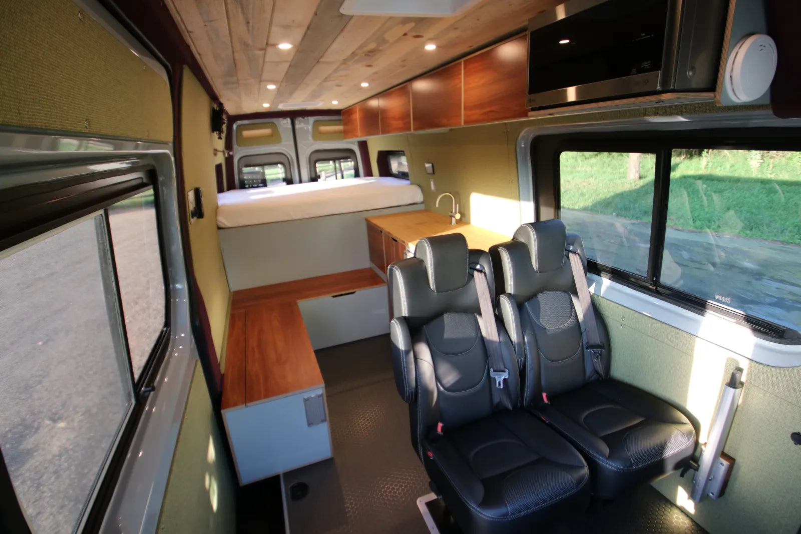 AL Sprinter 170 full interior with walnut cabinetry, four captain chairs, and elevated bed