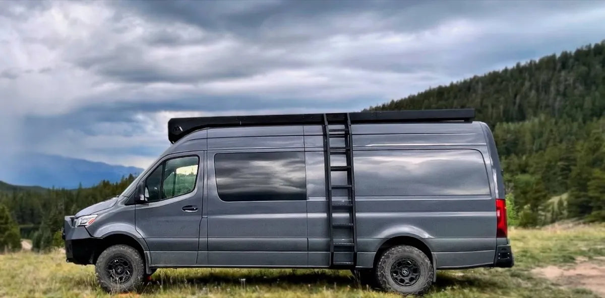 Bamboo Sprinter 170 gray van conversion with ladder and roof rack in the mountains by The Vansmith