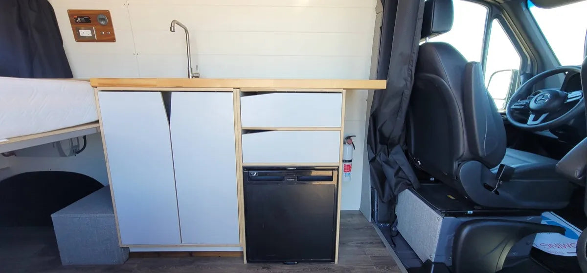 Cedar Sprinter 144 4x4 interior with maple kitchen, sink, fridge, and floating bed by The Vansmith