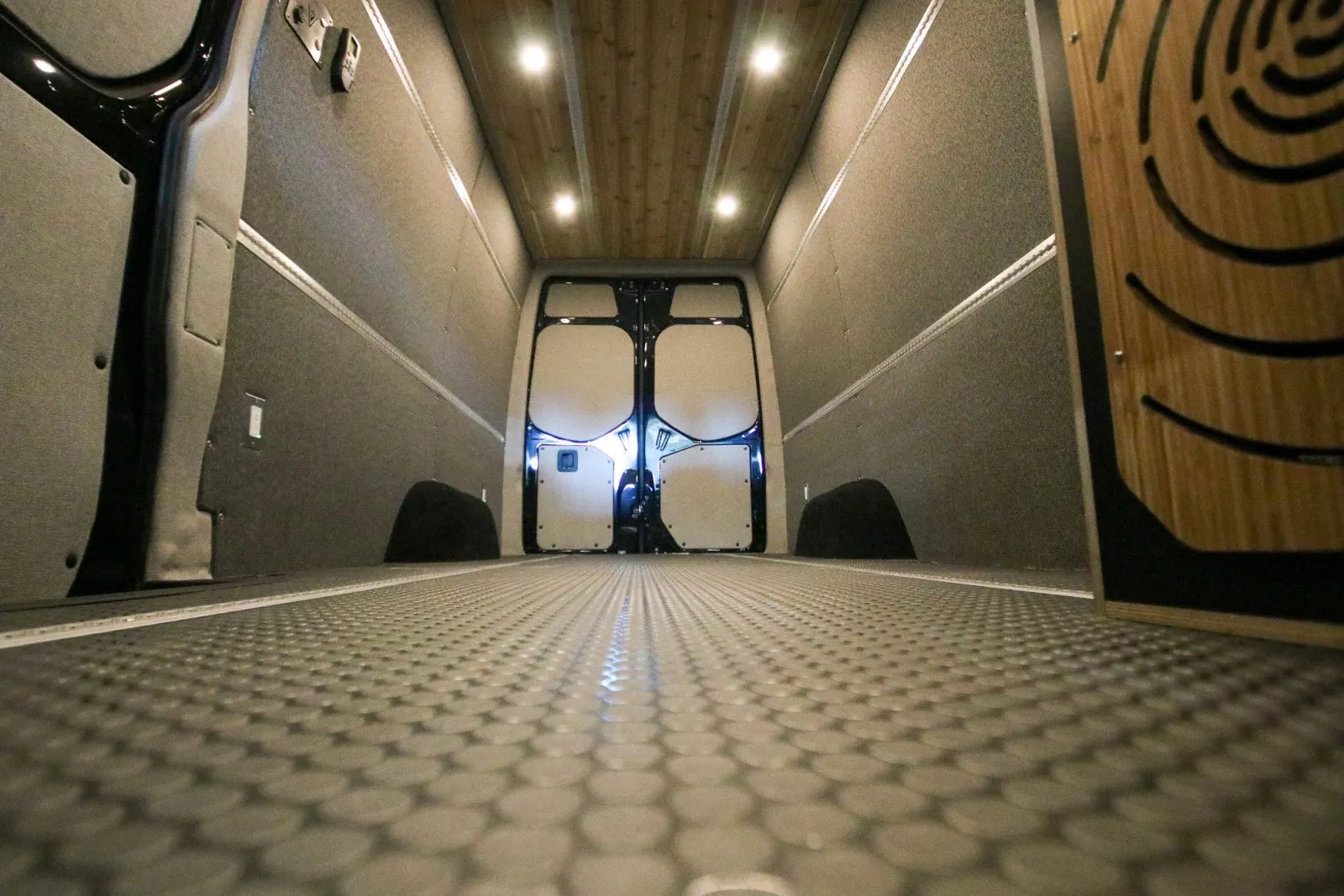 Insulated cargo area with cedar ceiling and diamond-plate flooring in Foundation Sprinter van
