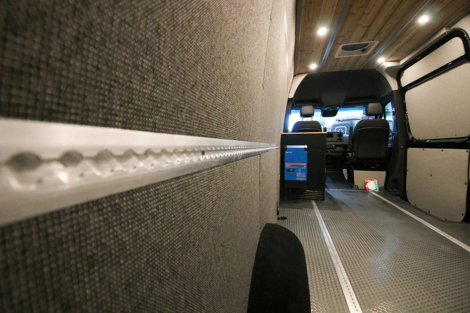 L-track wall rail system with insulated panels inside Foundation Sprinter van conversion